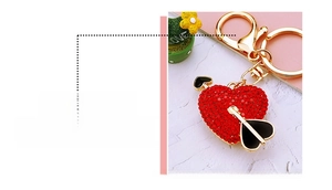 Detail of red rhinestone heart keychain with cupid arrow and golden metal clasp