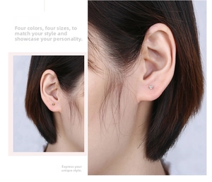 Detail showing minimalist gold and silver round ball stud earrings on model's ear