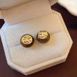 Detailed view of round brown tiger eye stone stud earrings with gold metal accents