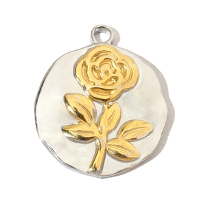 Macro shot of silver circular pendant featuring a detailed golden rose flower relief