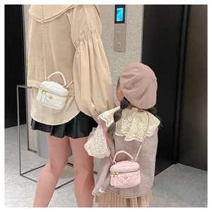 Detail shot of women and girls wearing matching quilted chain bags in pink and white