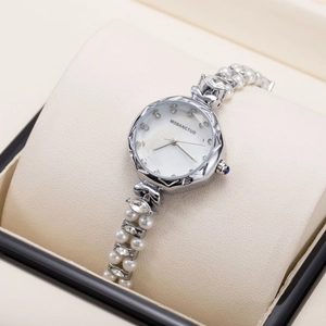 Detail of luxury women's quartz watch with pearl bracelet and marquise rhinestones