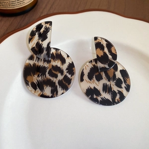 Detail of leopard print geometric earrings in a vintage acrylic and acetate style