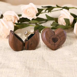 Detail of heart-shaped walnut wood ring box with romantic engraved poem for weddings