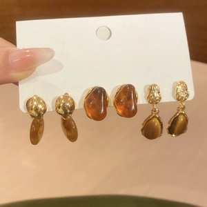 Vue détaillée d'un ensemble de boucles d'oreilles rétro en résine ambre et métal doré