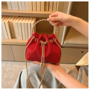 Detailed view of red rhinestone bucket bag with gold circular handle and tassel drawstring