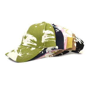 Detailed close-up showing a stack of six colorful tie-dye baseball caps in twill cotton