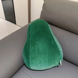 Macro detail of avocado plush pillow side label on a soft green textured fabric surface