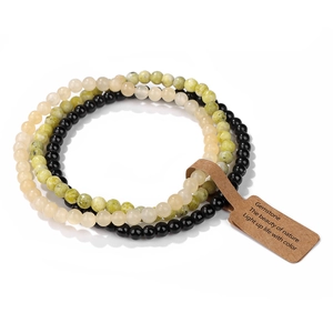 Detailed view of three 4mm natural picture agate stretch bracelets with paper gift tags