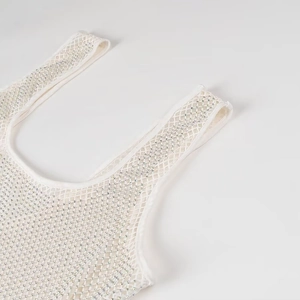 Gros plan sur une robe de soirée en résille blanche avec strass argentés et bretelles