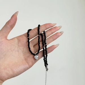 Close-up of S925 silver necklace with black faceted beads and heart crystal pendant