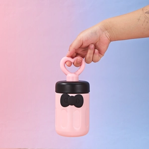 Close-up of pink stainless steel cup with black bow and heart-shaped handle strap