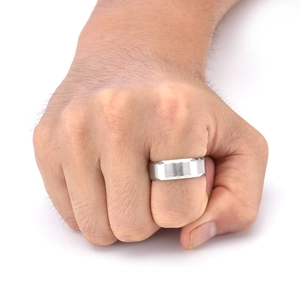 Detail of 8mm silver titanium steel ring with geometric faceted edges on male hand