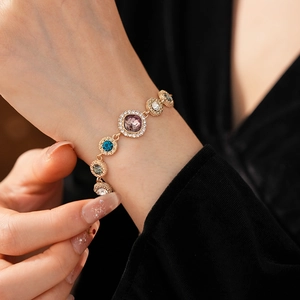 Close-up of sparkling colorful gemstone bracelet with rhinestones on a black background