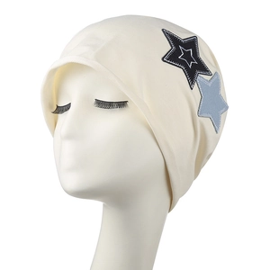 Chic cream knit beanie with star embroidery patches on a minimalist mannequin head