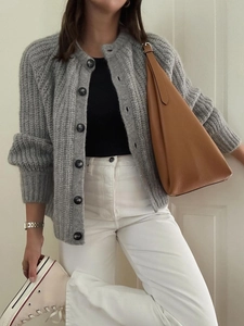 Chic women's grey knitted cardigan styled with white trousers and a brown handbag