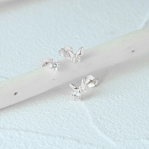 Detailed view of S925 sterling silver butterfly and zircon stud earrings on a branch