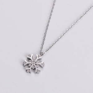 Macro shot of silver snowflake pendant necklace featuring delicate zircon stone inlays