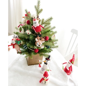 Handmade wool felt Christmas ornaments featuring Santa, snowman, and reindeer on a tree