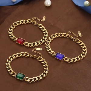 Trois bracelets gourmette en acier doré avec cristaux rouges, bleus et verts