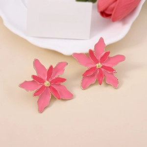 Detailed view of layered pink flower earrings with yellow stamen and gold metal edges