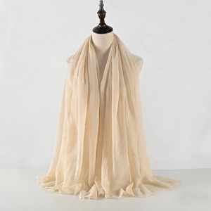 Sciarpa beige in cotone e lino stropicciato da donna con frange su un manichino