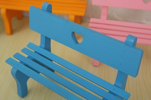 Close-up of mini wooden garden benches with heart-shaped cutouts for micro landscapes