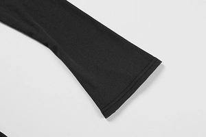 Detailed macro view of the black ribbed knit fabric and sleeve stitching on the dress