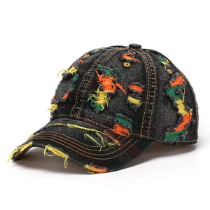 Close-up of distressed denim baseball cap with colorful patchwork and frayed hole details
