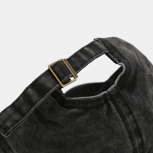 Detail of vintage washed baseball cap with adjustable brass buckle and canvas strap