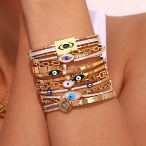 Detail of 18K gold-plated Evil Eye stack bracelets with micro-pave crystals on wrist