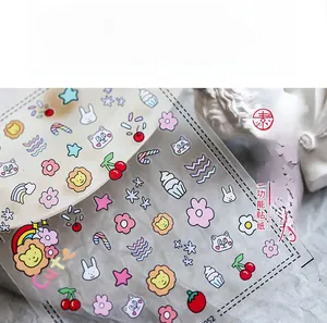 Detail of ultra-thin nail art stickers featuring cute cartoon animals and cherry motifs