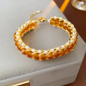 Macro shot of vintage titanium steel bracelet with amber crystals and white pearls in a box