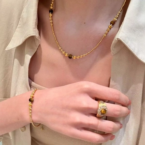 Detail of 18k gold plated tiger eye jewelry set including necklace, bracelet and ring
