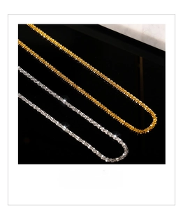 Macro shot of gold and silver textured chain necklaces with sparkling weaving detail