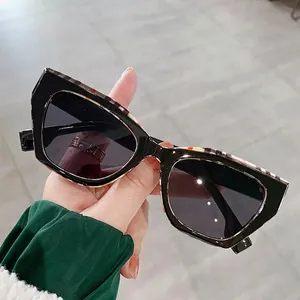 Chic black cat-eye sunglasses with checkered pattern upper frame and dark lenses