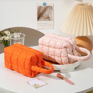 Quilted puffer makeup bag set in orange and pink with durable top handles and zippers