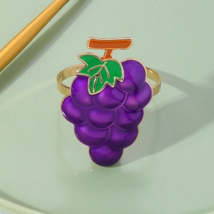 Detail shot of purple grape napkin ring with gold band on a green plate