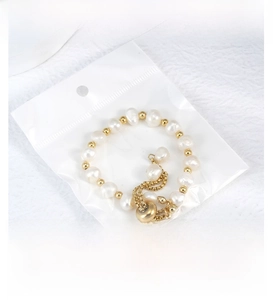 Detail of freshwater pearl bracelet with gold beads in a protective clear packaging