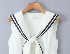 Detail of white sleeveless top showing nautical sailor collar with blue stripes and bow