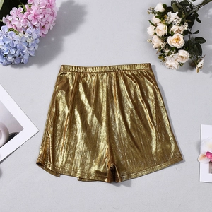 Detail of metallic gold shorts with elastic waistband and pleated fabric texture