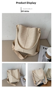 Detail view of cream white bucket bag with crocodile texture and wide canvas strap