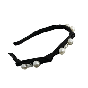 Elegant black fabric headband with large white pearls and square crystals in studio light