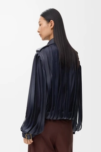 Rear view of a dark blue leather jacket featuring fringe details and metal buckles