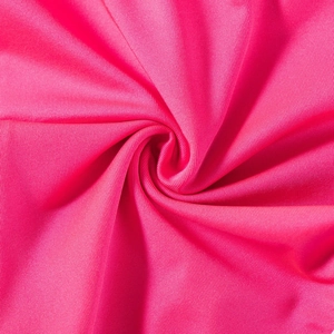Macro shot of rose red yoga shorts fabric showing smooth stretch texture and fine weave