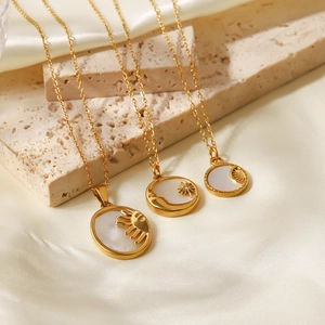 Colliers en acier doré 18K avec pendentifs soleil et lune en nacre sur fond de soie