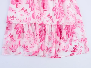 Détail de l'imprimé fleuri rose sur mousseline et volants d'une robe longue à étages
