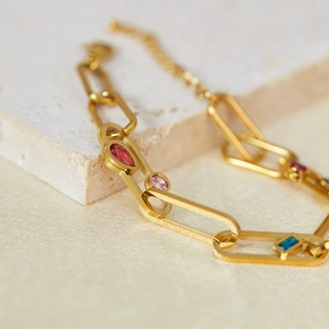 Bracelet élégant à maillons dorés serti de pierres de zircon colorées sur décor pierre
