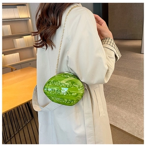 Detailed view of green watermelon-shaped acrylic clutch with gold chain shoulder strap