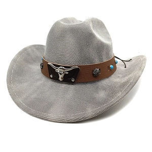 Detailed view of woven cowboy hat with leather band and turquoise metal cow skull buckle